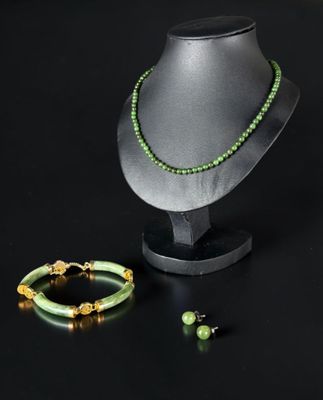 green beaded necklace and bracelet set on a mannequin stand