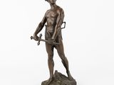 une statue en bronze représentant un homme tenant une épée