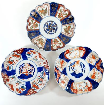 three plates with different designs on them sitting on a white surface
