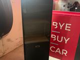 a black refrigerator next to a red and white sign