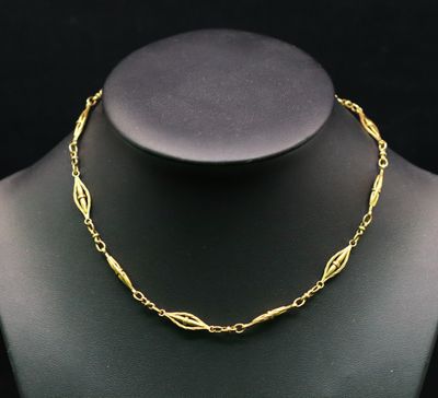 un collier en or autour du cou d'un mannequin, sur fond noir