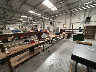 une grande salle où se trouvent de nombreuses tables et des bancs