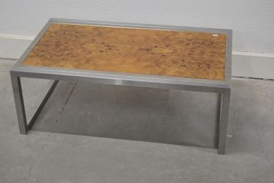 une table en métal avec un plateau en bois posée sur un sol en béton