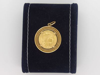 une petite pièce d'or dans un étui en velours sur fond blanc