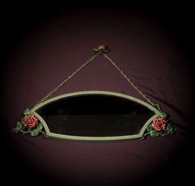 a mirror hanging on the wall with roses on it