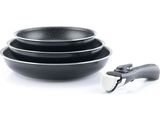 deux casseroles noires et une spatule posées sur une surface blanche