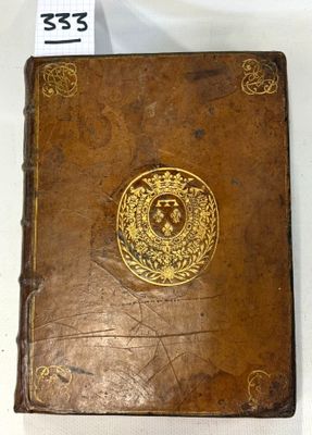 an old brown book with a gold emblem on it