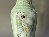 a green vase with a picture of a woman on it