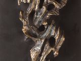 an image of a bronze sculpture of a flower on a black surface
