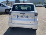 a small white car that is parked in a parking lot