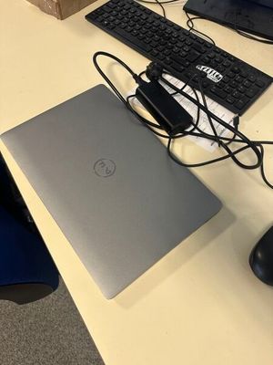 un ordinateur portable et un clavier posés sur un bureau, avec une souris à côté