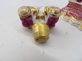 a white and pink vase with gold decorations on it