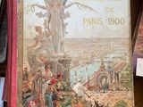 un vieux livre sur lequel figure l'image d'une femme, posé sur une table à côté d'autres livres