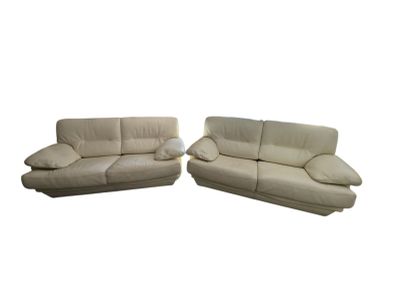 ensemble composé d'un canapé et d'une causeuse en cuir couleur crème, avec des coussins