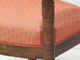 a wooden chair with an orange upholstered seat