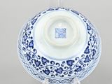 a blue and white bowl on a clear stand