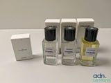 trois flacons de parfum posés l'un à côté de l'autre sur une table
