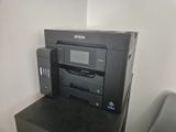 a printer sitting on top of a desk next to a chair