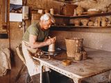 a man that is making a pot on a table
