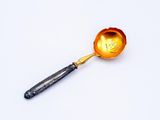 a spoon with a handle that has a flower on it