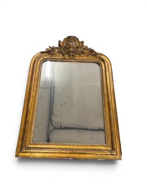 a mirror with a gold frame on a white wall