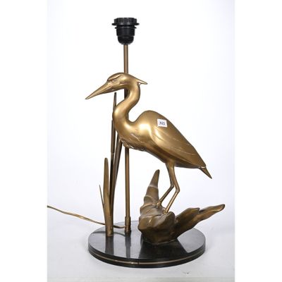 une photo d'une lampe en bronze représentant un héron, posée sur un socle noir