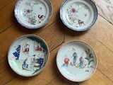 three plates with designs on them are sitting on a wooden floor