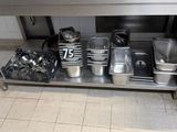 many pots and pans sitting on a stainless steel table