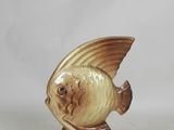 a small figurine of a fish on a stand