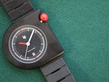 a black watch with a red bead on it