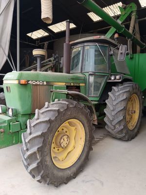 a green tractor that is parked in a garage