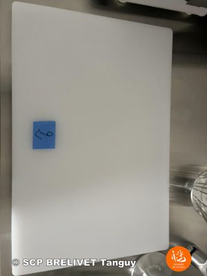 a white board with a blue sticker on it in a kitchen