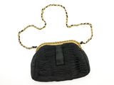 un sac à main noir entouré d'une chaîne dorée, sur fond blanc