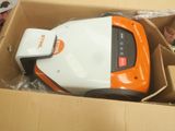 un aspirateur orange et blanc dans une boîte en carton
