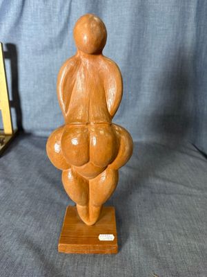 wooden sculpture of a woman holding a baby on a wooden base