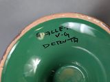 a close up of a green vase with writing on it