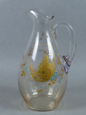 a glass pitcher with a gold and blue design on it