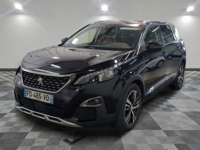 la voiture noire est garée sur un sol en damier dans le garage