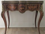 a small wooden table with a mirror on top of it