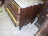 une vieille commode avec un plateau en marbre dans une pièce