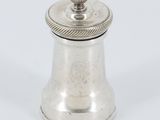 une poivrière ancienne en argent sur fond blanc