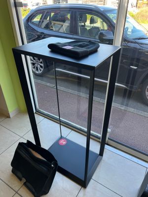 a bag sitting on the floor in front of a glass display case