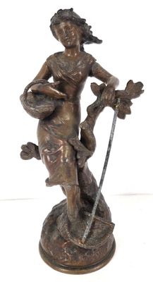statue en bronze représentant une femme tenant une épée et un oiseau, posée sur un socle