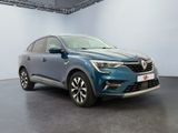 a blue car parked in a large room with a white wall