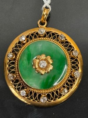 an image of a green and gold pendant with a flower on it