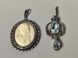 deux pendentifs représentant chacun une femme et une topaze bleue