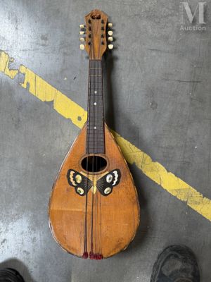 une personne debout à côté d'une guitare sur laquelle est peint un visage