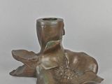 a bronze vase with a flower in it on a table