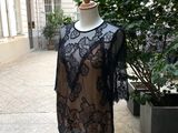 black lace dress on a mannequin stand in front of a building