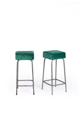 a pair of green velvet stools with metal legs